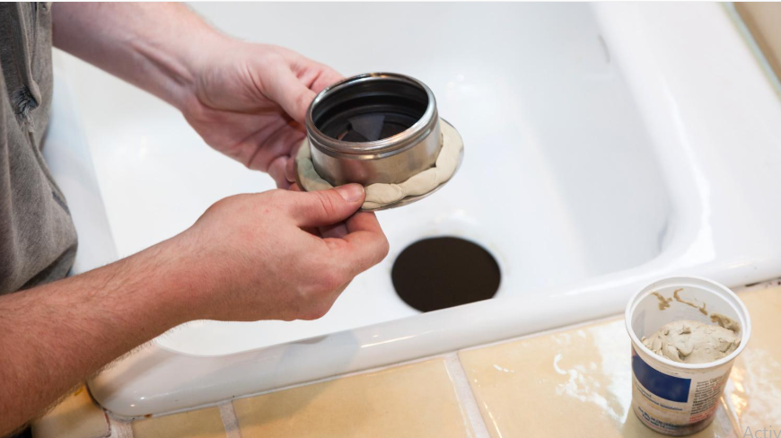 Applying a suitable waterproof sealant around a kitchen sink drain to help prevent water leaks.