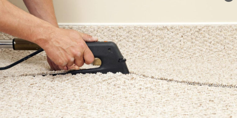 Carpet seaming using a heat-bond iron to join two carpet edges with heat-activated adhesive tape.