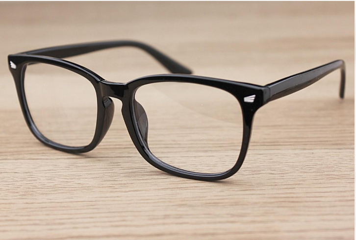 Black plastic eyeglasses viewed after inspection following a repair, showing the frame and repaired area.