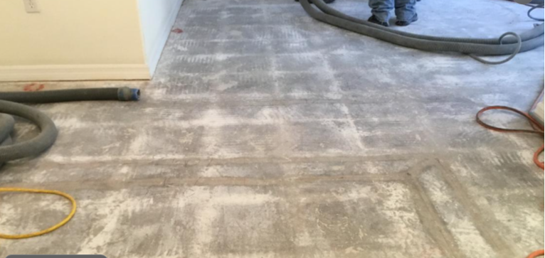 Clean, smooth concrete floor after removing old tiles and adhesive, prepared for installing new floor tiles.