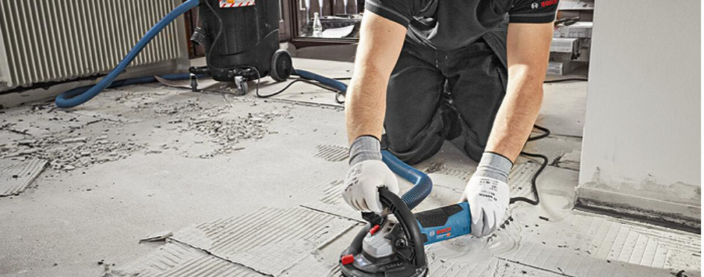 Applying a commercial tile adhesive remover to stubborn old tile adhesive on a concrete floor.